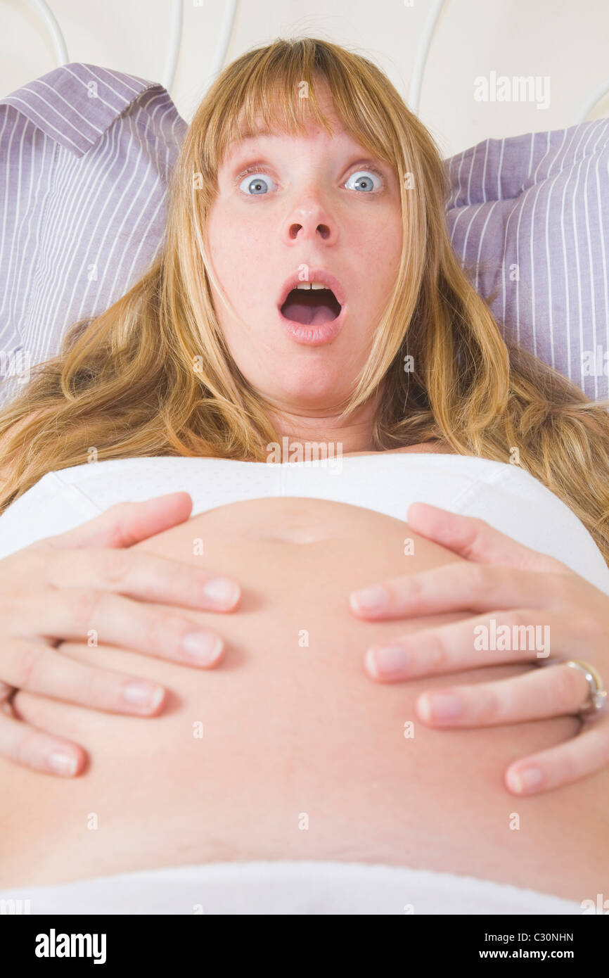 Schwangere Frau im Bett Gefühl Kontraktionen. Stockfoto