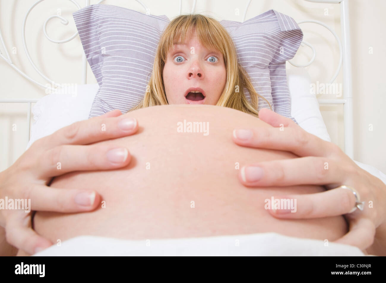 Schwangere Frau im Bett Gefühl Kontraktionen. Stockfoto