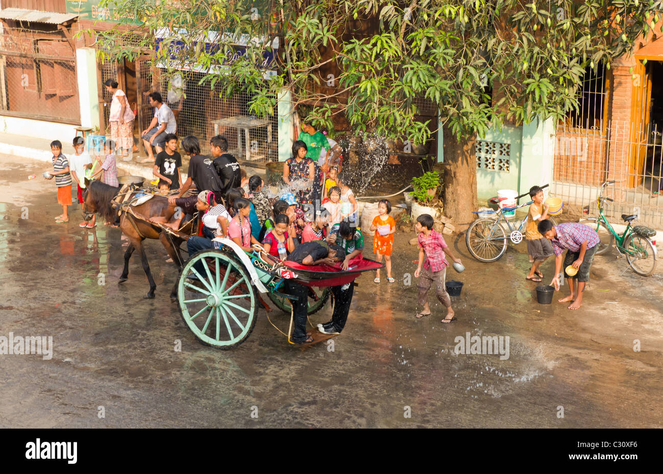 Menschen auf der Pferdekutsche, die immer mit Wasser bei Thingyan, wasserfest in Mandalay, Myanmar übergossen Stockfoto