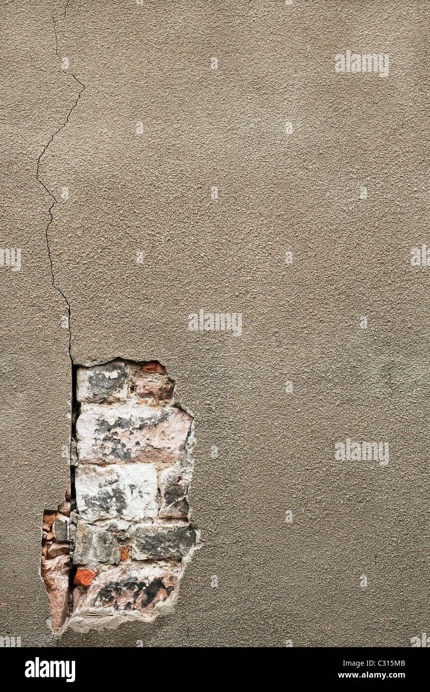 Eine Betonwand hat geknackt und zerbröckelte um die alten Ziegelsteine unten sichtbar zu machen. Berwick nach Tweed, Northumberland, England, UK Stockfoto
