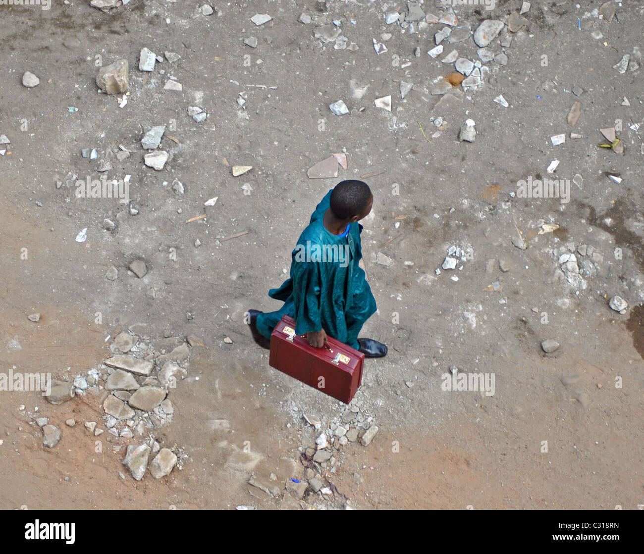 Luftaufnahme des muslimischen Geschäftsmann mit Aktenkoffer durch Schmutz Straßen im Stadtteil Treichville, Abidjan, Elfenbeinküste Stockfoto
