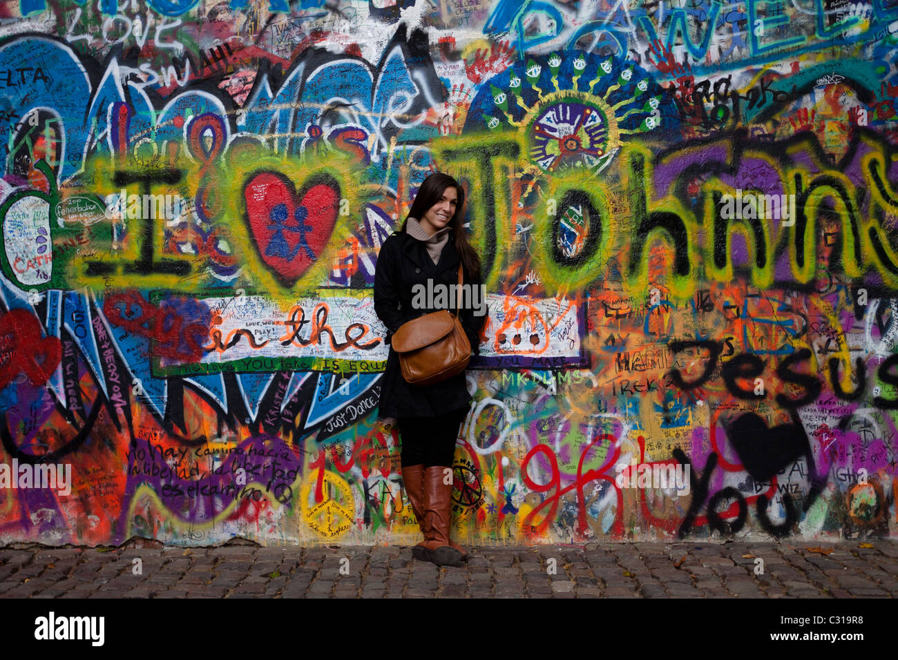Eine schöne Frau hat ihr Foto vor der John-Lennon-Mauer Stockfoto