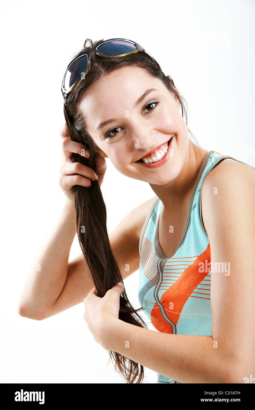 Froh, dass die junge Frau ihr langes Haar hält und Blick auf Kamera Stockfoto
