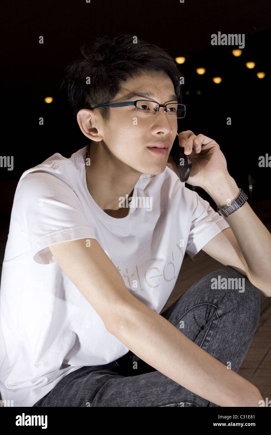 Asia junge Mann sprechendes Telefon Stockfoto