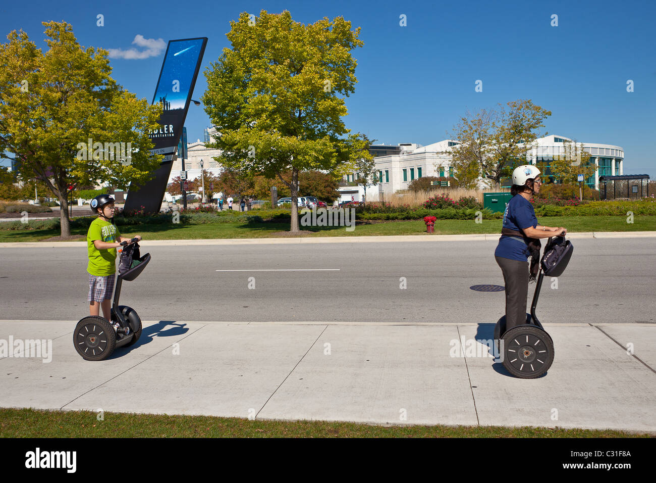 Segway-Fahrer passieren das Adler Planetarium und Field Museum of Natural History in Chicago, IL, USA. Stockfoto
