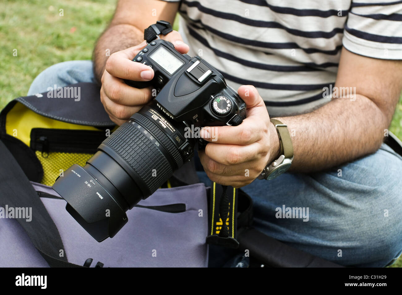 Ein scharfer männlichen Fotografen untersucht seine Kamera.  Person ist nicht erkennbar Stockfoto