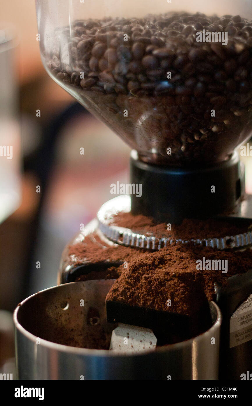 Kaffeesatz aus einer Kaffeemühle zu verschütten. Stockfoto