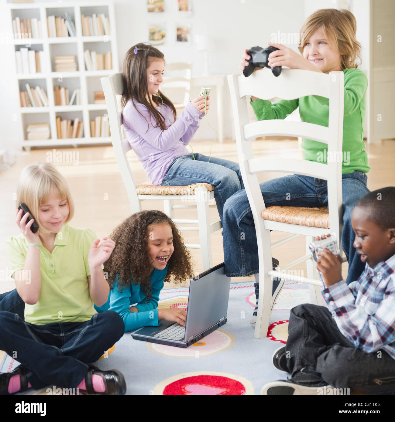 Kinder spielen mit verschiedenen Technologien zusammen Stockfoto