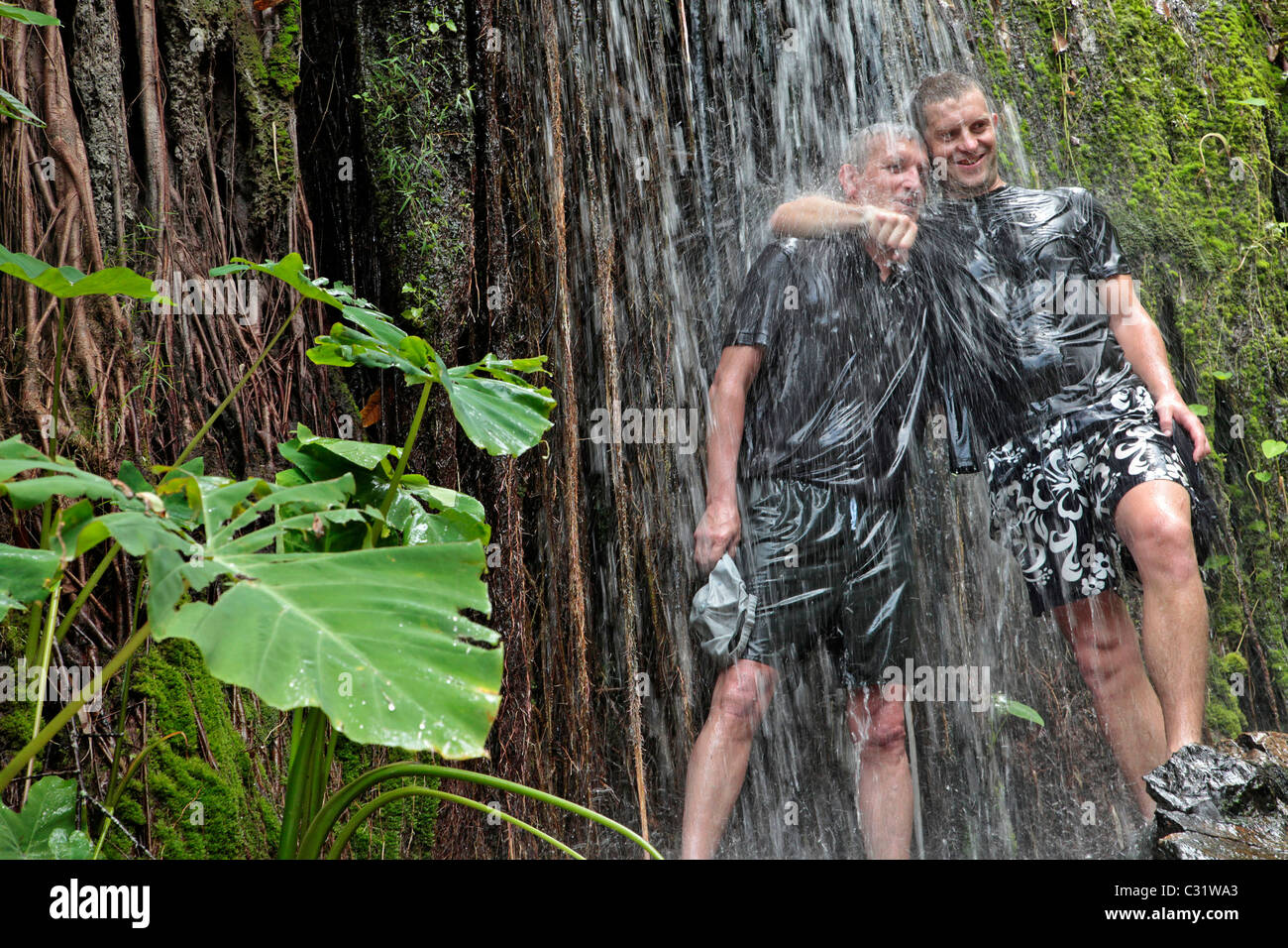 "COOLING OFF" UNTER EINEM WASSERFALL, TREKKING IM DSCHUNGEL, NATURSCHUTZGEBIET IN DER REGION VON BANG SAPHAN, THAILAND, ASIEN Stockfoto