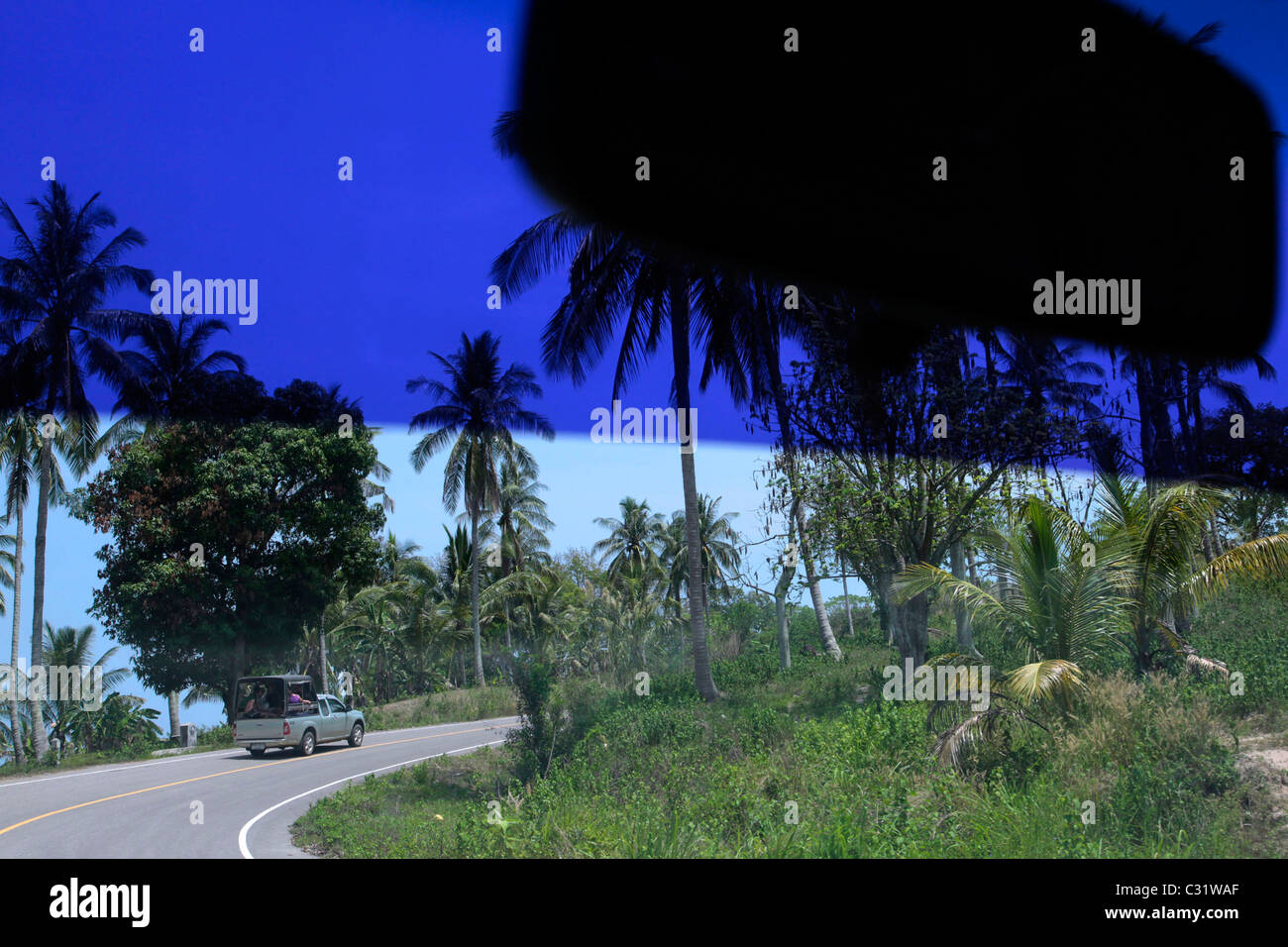 PICKUP-TRUCK AUF DER STRAßE GESEHEN HINTER DER WINDSCHUTZSCHEIBE EINES ANDEREN AUTO, BANG SAPHAN, THAILAND, ASIEN Stockfoto