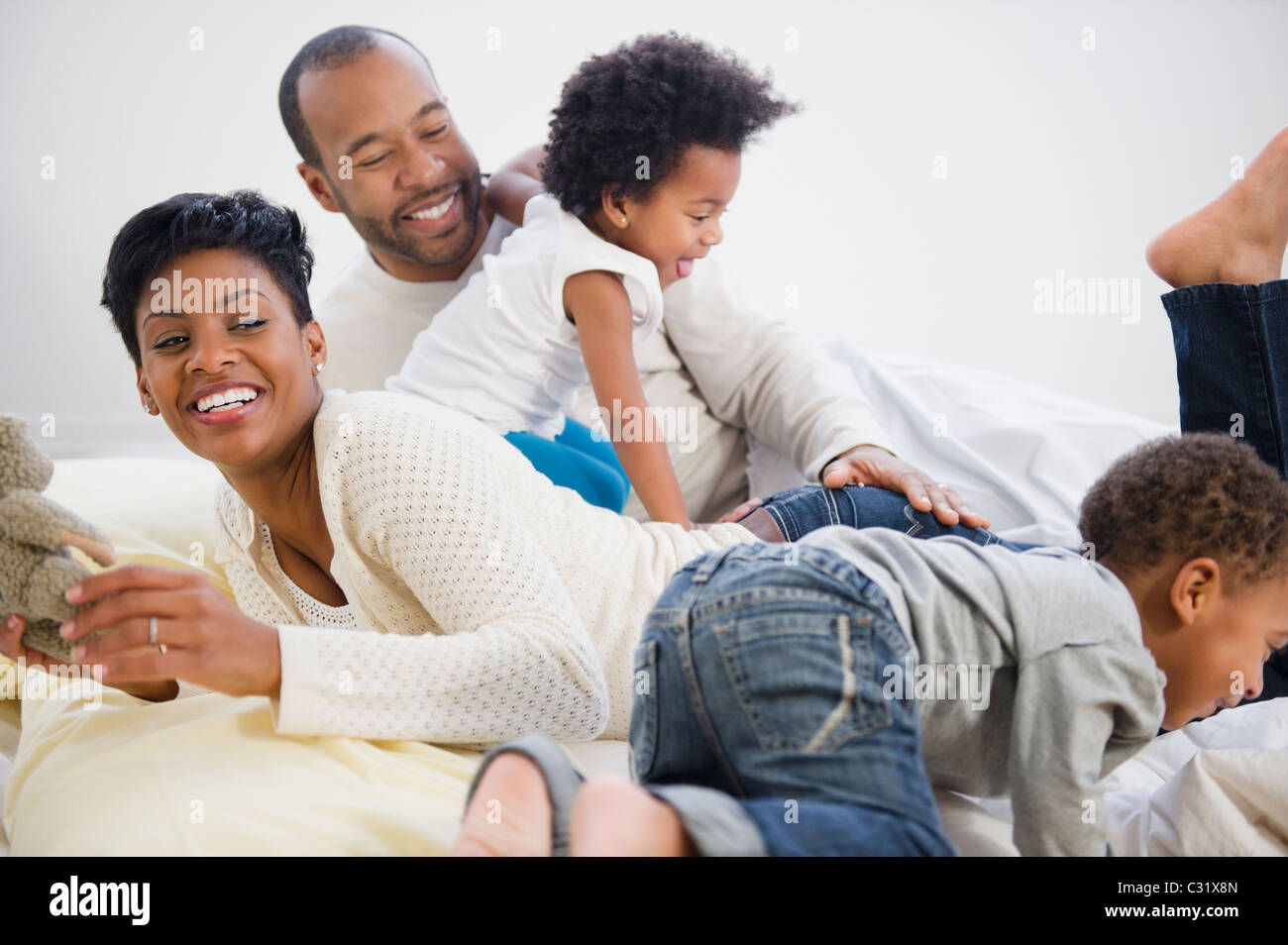 Schwarze Familie mit auf Bett zusammen Stockfoto