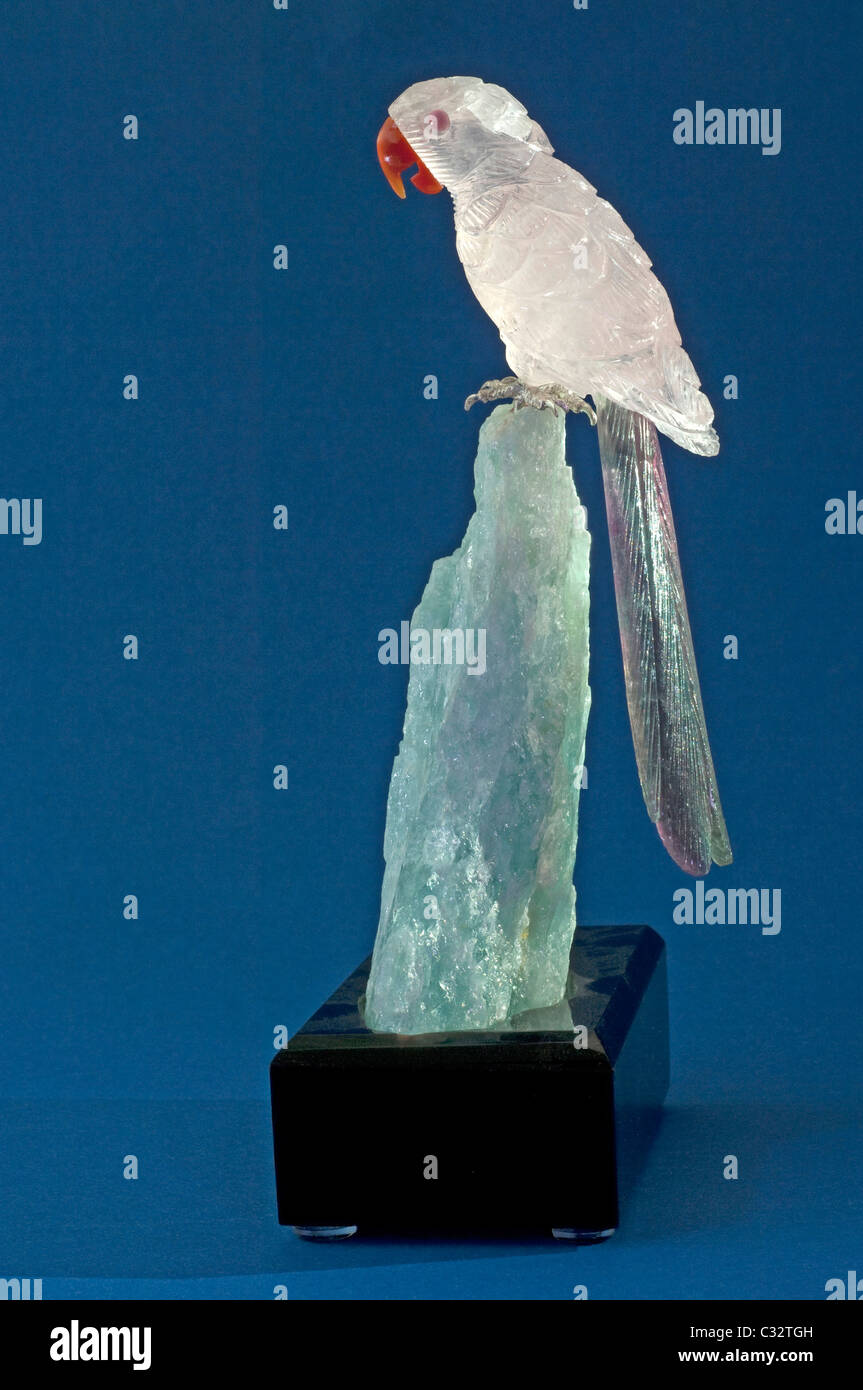Ara aus Rosenquarz und Fluorit gehockt Aquamarin. Studio Bild vor einem blauen Hintergrund. Stockfoto