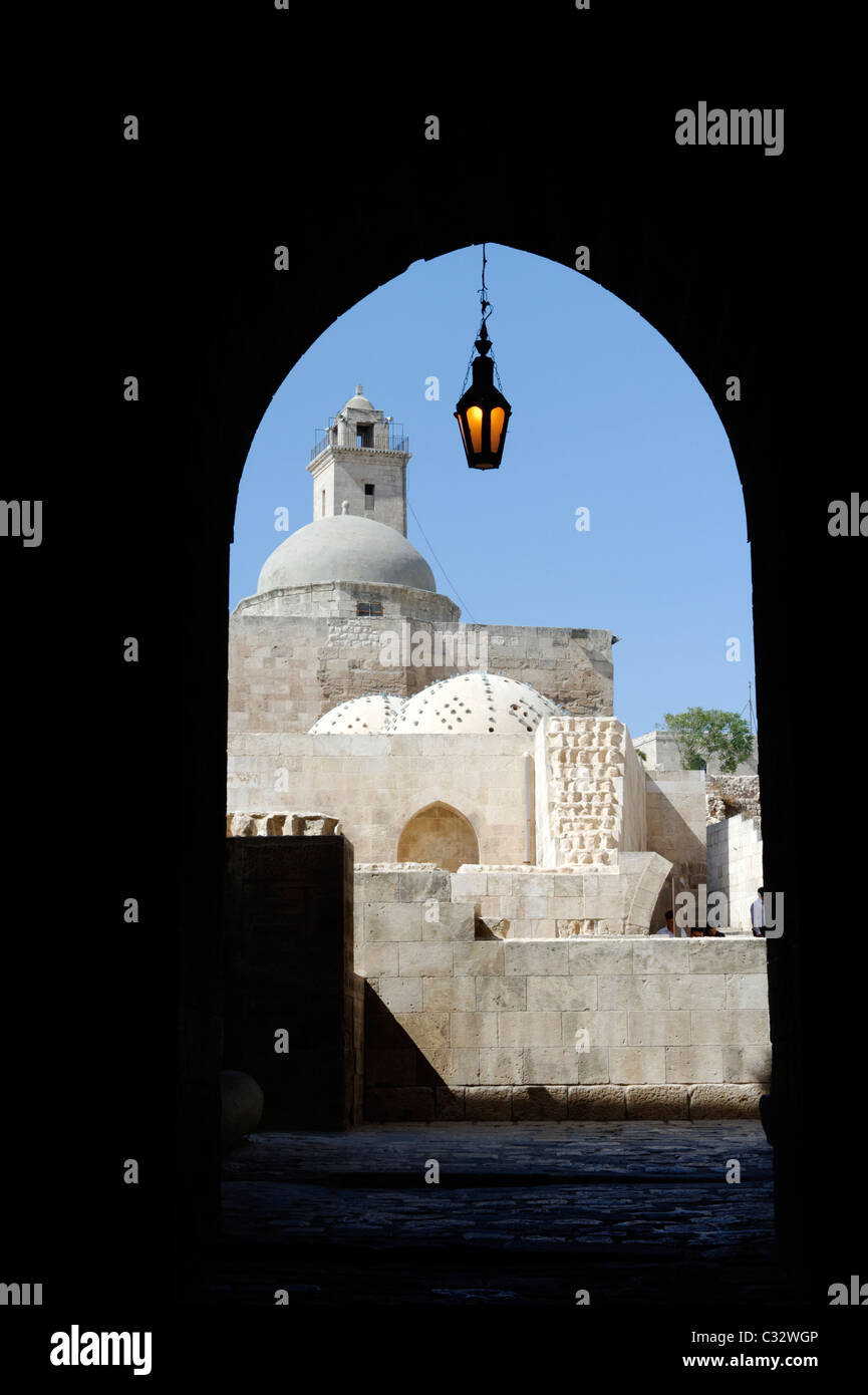 Reich verzierte Laterne hängt an der gewölbten inneren Eingang zur Zitadelle mit dem Minarett der großen Moschee sichtbar. Aleppo. Syrien. Stockfoto