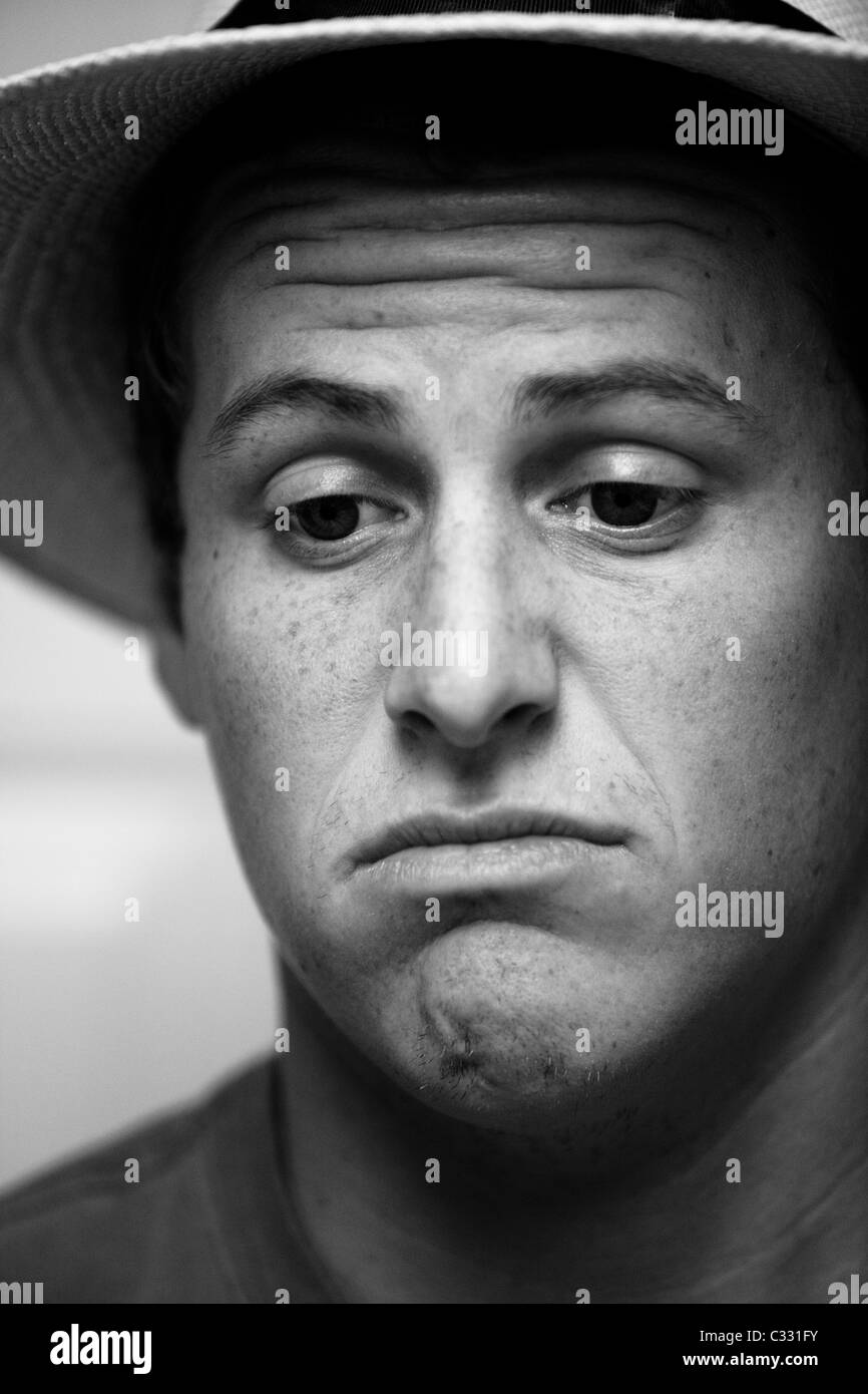 Schwarze und weiße Kopfschuss von einem jungen Mann runzelte die Stirn und einen Hut in Camarillo, Kalifornien hautnah. Stockfoto