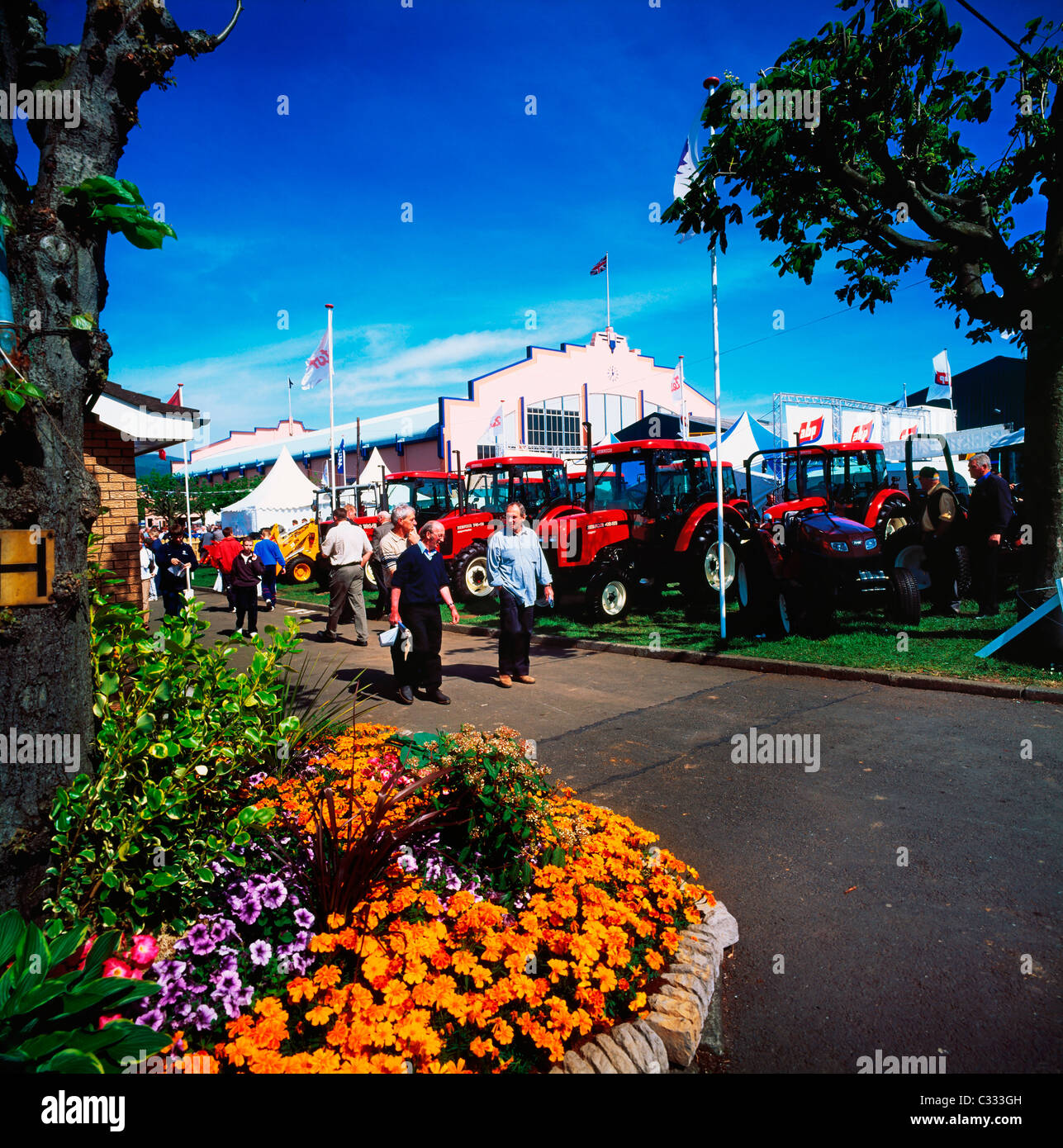 Menschen zu Fuß durch Traktoren Stockfoto