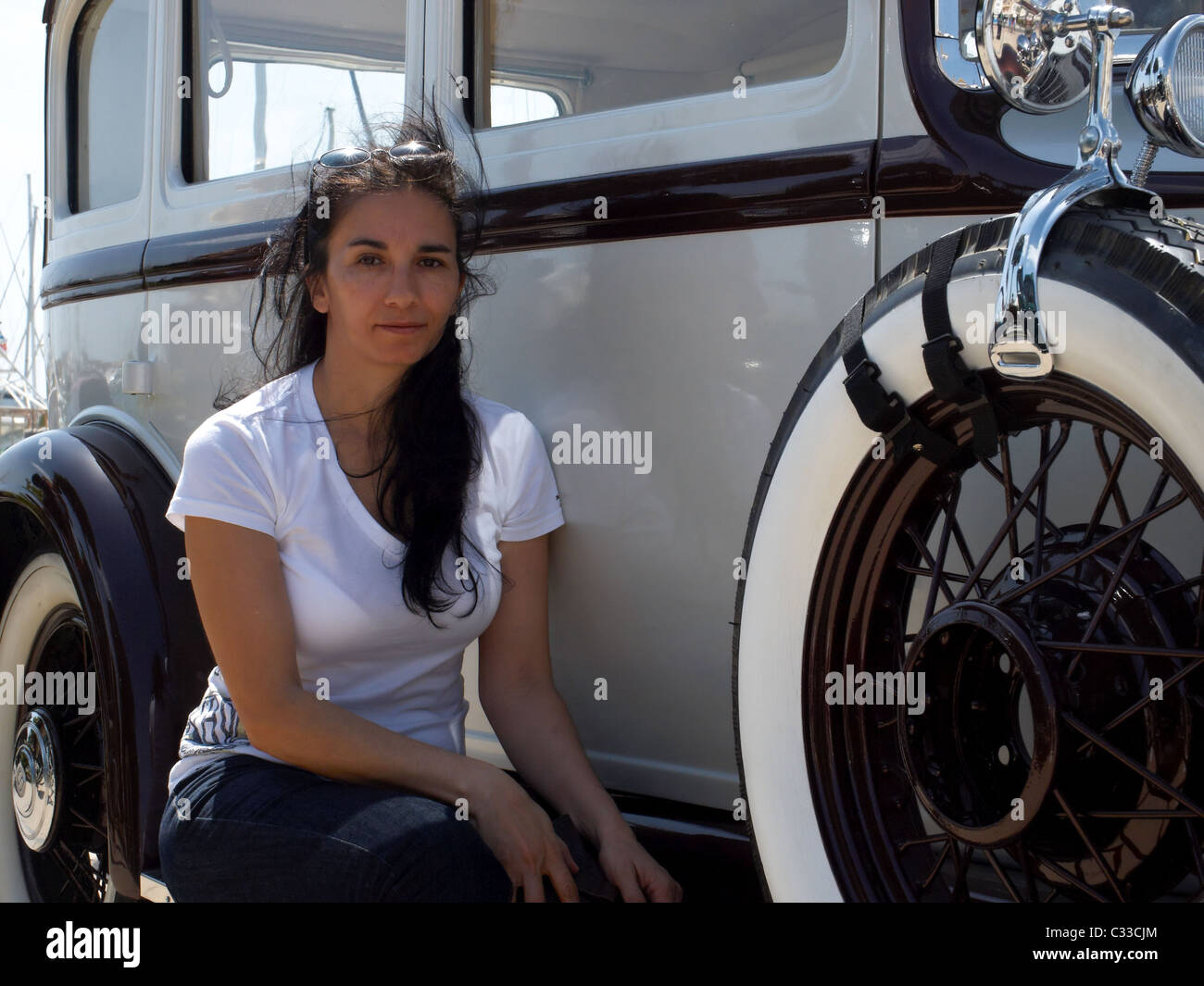 -Schöne Frau sitzt im klassischen Auto- Stockfoto