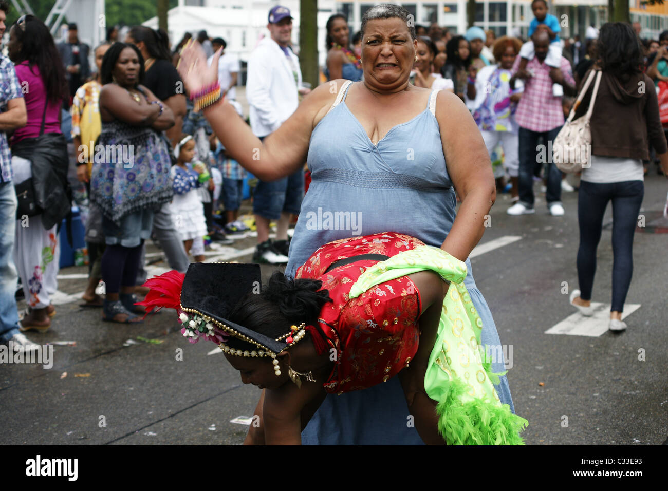 Dicke Frau schlagen kostümierte Tänzer im Sommer Karneval Festival Rotterdam Straßenkampf Stockfoto
