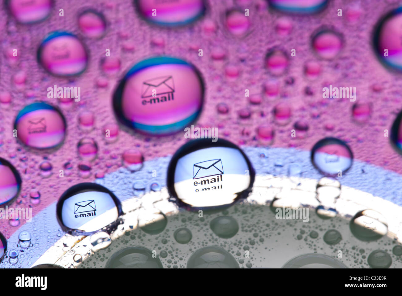 Briefumschlag-Symbol spiegelt sich in den Wassertropfen. Nahaufnahme von Wassertropfen platziert auf einer DVD Stockfoto