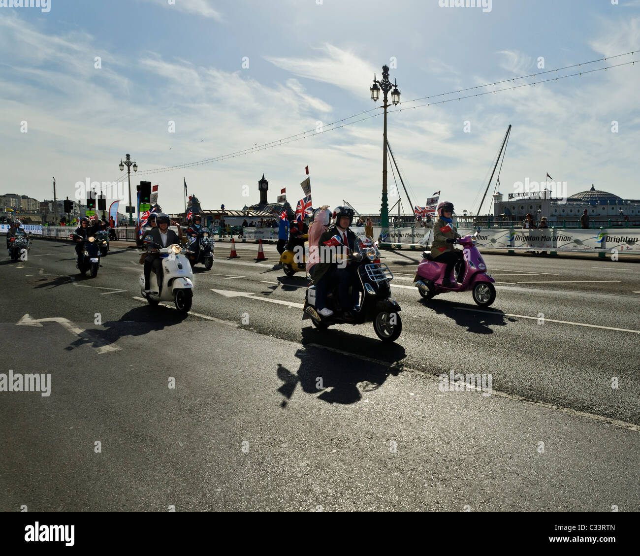 Mods auf Rollern übergeben dem Brighton Pier in Brighton Sonnenschein. Stockfoto