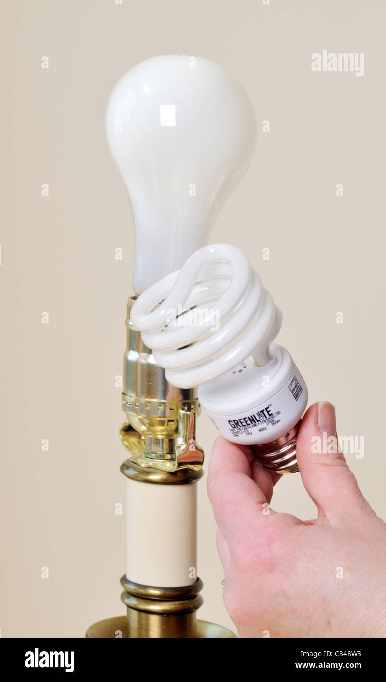 Austausch der Glühbirnen in einer Lampe aus einer Glühbirne zu mehr energiesparenden CFL-Lampe. Stockfoto