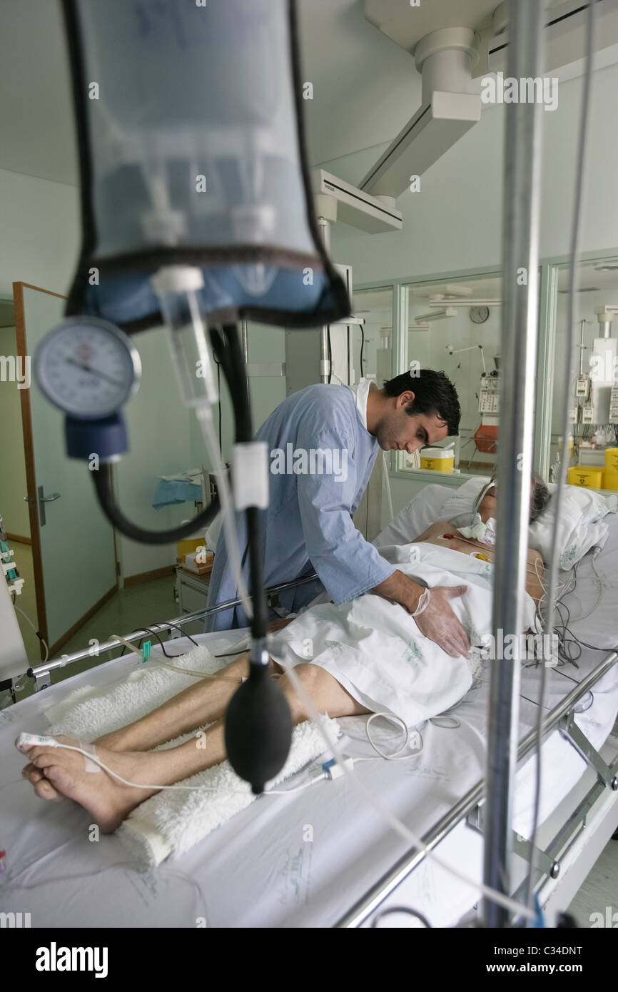Pfleger kümmert sich der Patient in einem Krankenhausbett Stockfoto