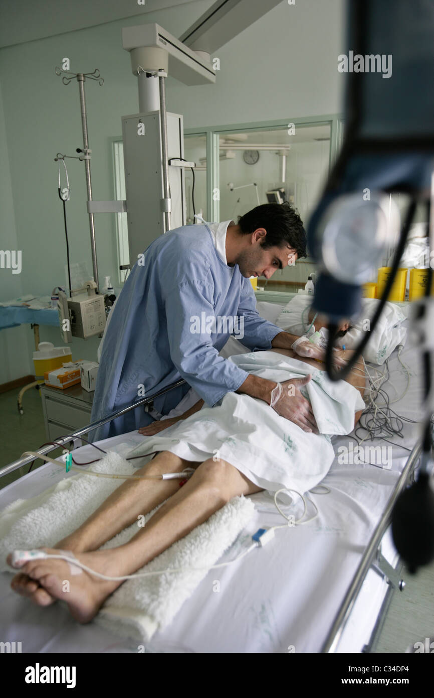 Pfleger kümmert sich der Patient in einem Krankenhausbett Stockfoto