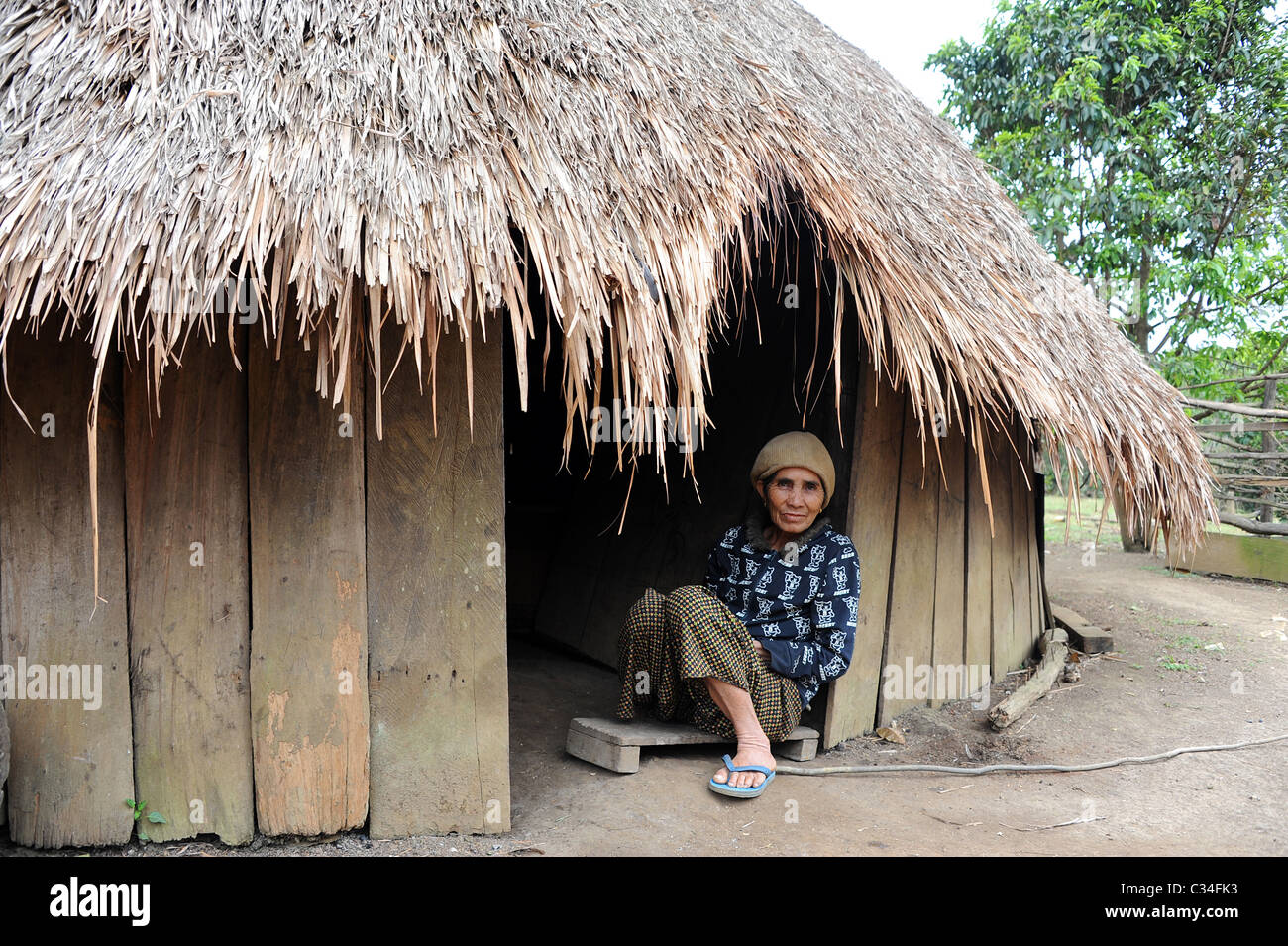 Frau sitzt vor der Tür zu ihrer ursprünglichen Heimat. Stockfoto