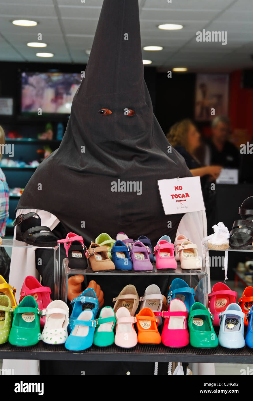 Dummy-Shop gekleidet als vermummte Büßer in Schuh-Shop während der Semana Santa in Sevilla, Andalusien, Spanien Stockfoto