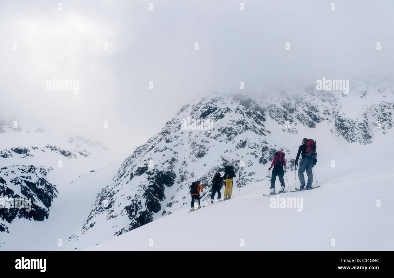 Eine Gruppe von Skitourengeher Klettern auf einem Berghang in Lyngen Alpen, Norwegen Stockfoto