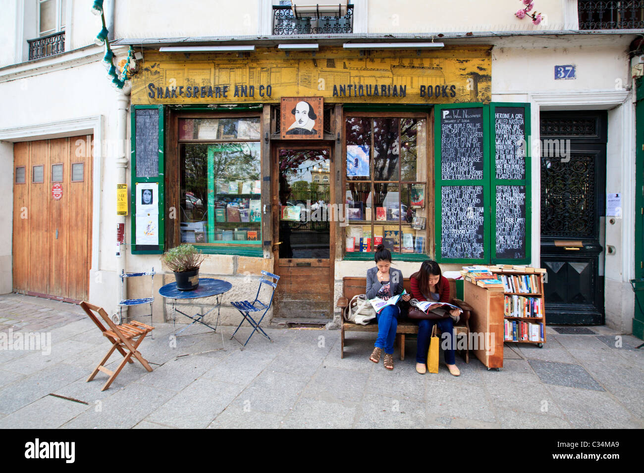Zwei Frauen, die vor der Buchhandlung Shakespeare and Company im Quartier Latin, Paris, lesen Stockfoto
