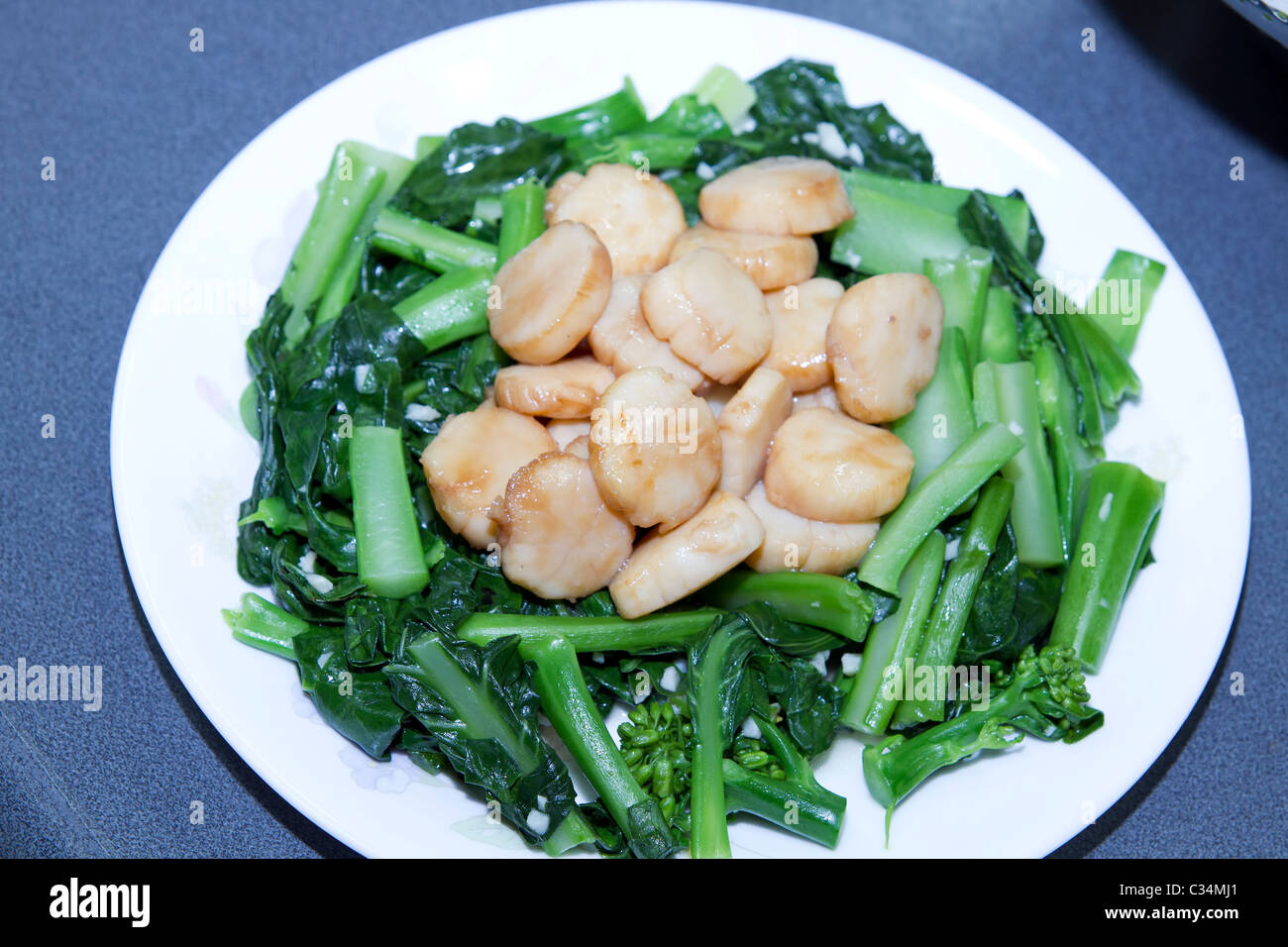 Stir Fry Meeresfrüchte Jakobsmuscheln Muscheln und grünen chinesischen Brokkoli-Gemüse Stockfoto