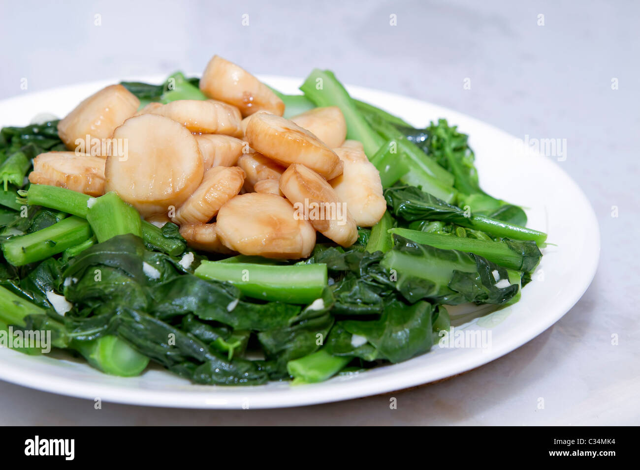 Stir Fry Meeresfrüchte Jakobsmuscheln und grünen chinesischen Brokkoli Gemüsegericht Stockfoto