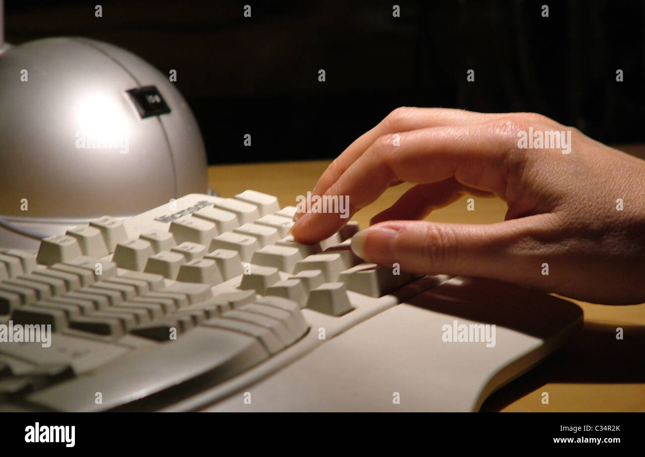 Weibliche Hand Sie am konturierte Microsoft-Tastatur eingeben Stockfoto