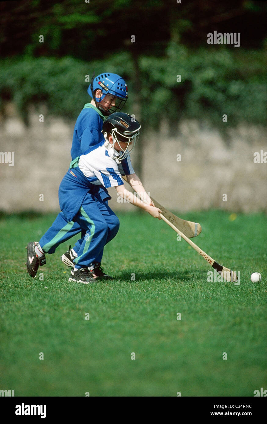 Kinder spielen Hurling, Irland-Gälischer Sport Stockfoto