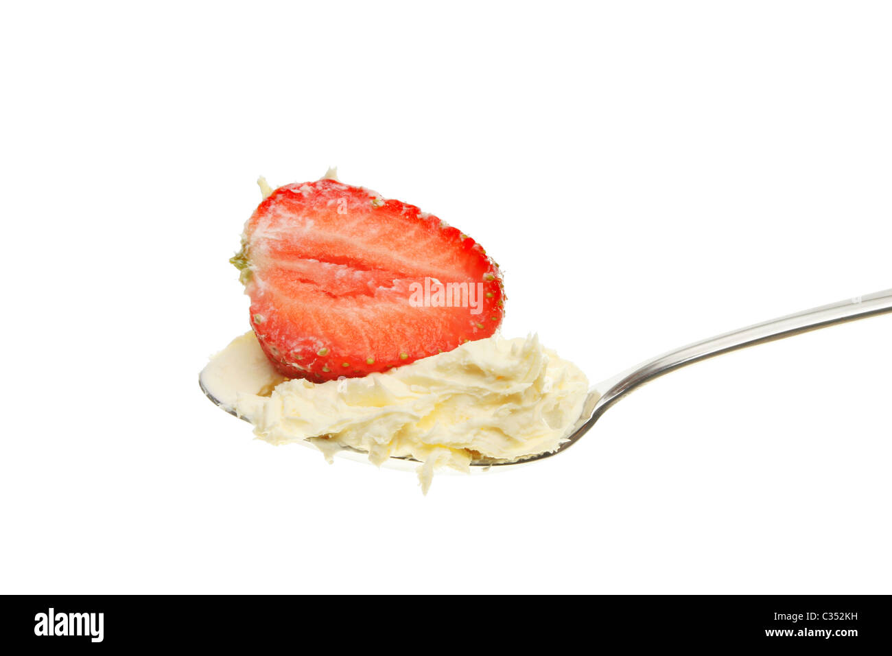 Erdbeeren und Sahne in einem Löffel isoliert gegen weiß Stockfoto
