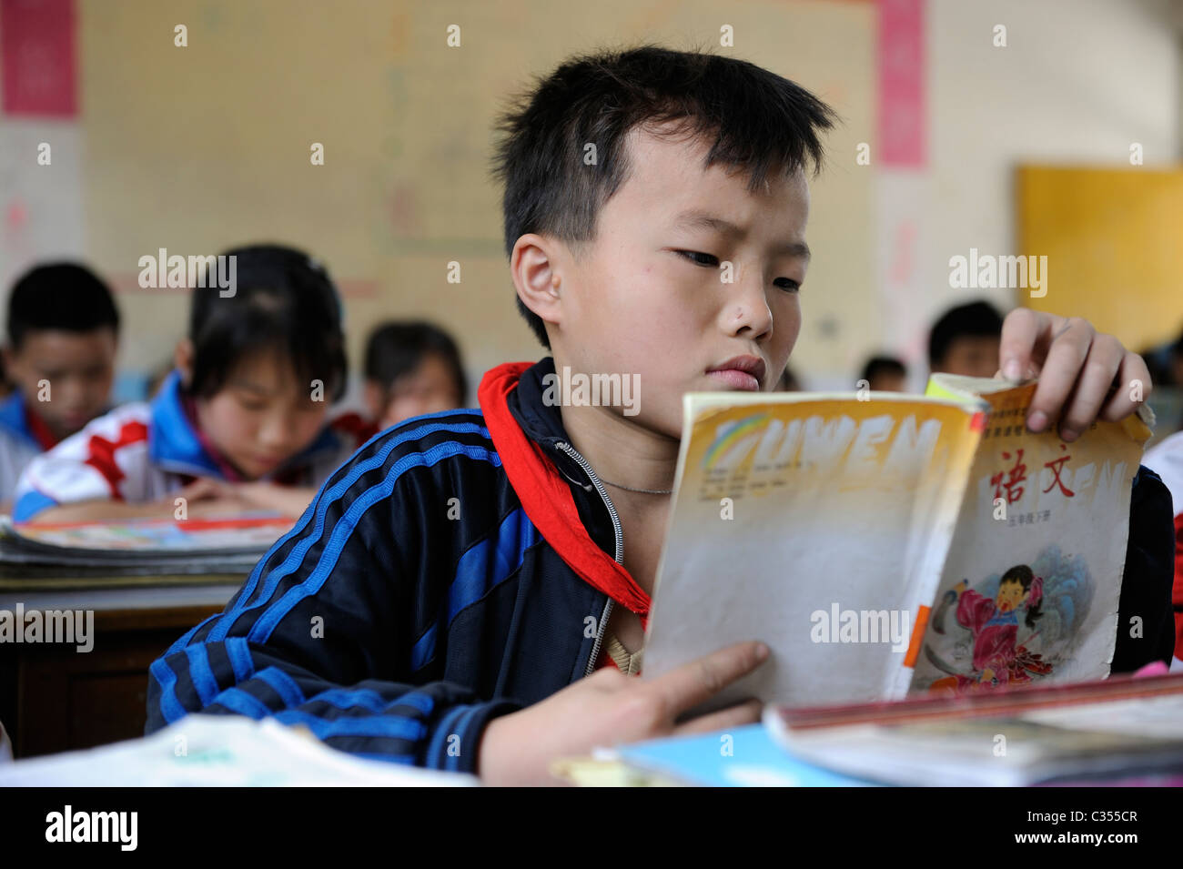Chinesische Grundschule Schüler hält Sprache Buch in remote-Landschaft in Duan County, Guangxi, China. 20. April 2011 Stockfoto