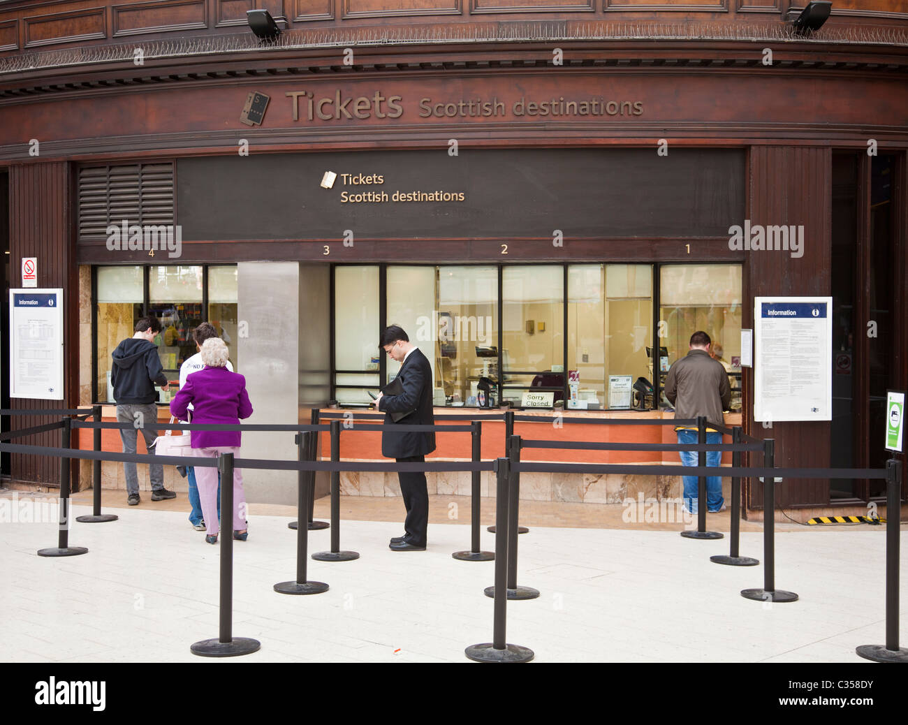 Passagiere warten und Kauf von Tickets an der Kasse in Glasgow Central Station, Scotland, UK Stockfoto