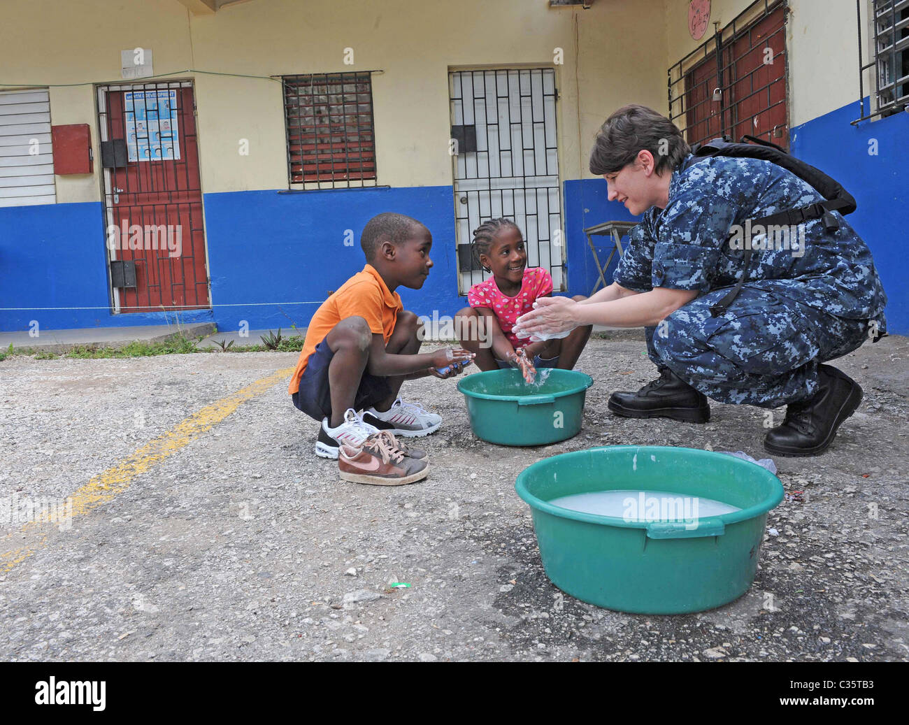 KINGSTON, Jamaika Frau lehrt Kinder ihre Hände zu waschen, während eine anhaltende Versprechen Community-Service-event Stockfoto