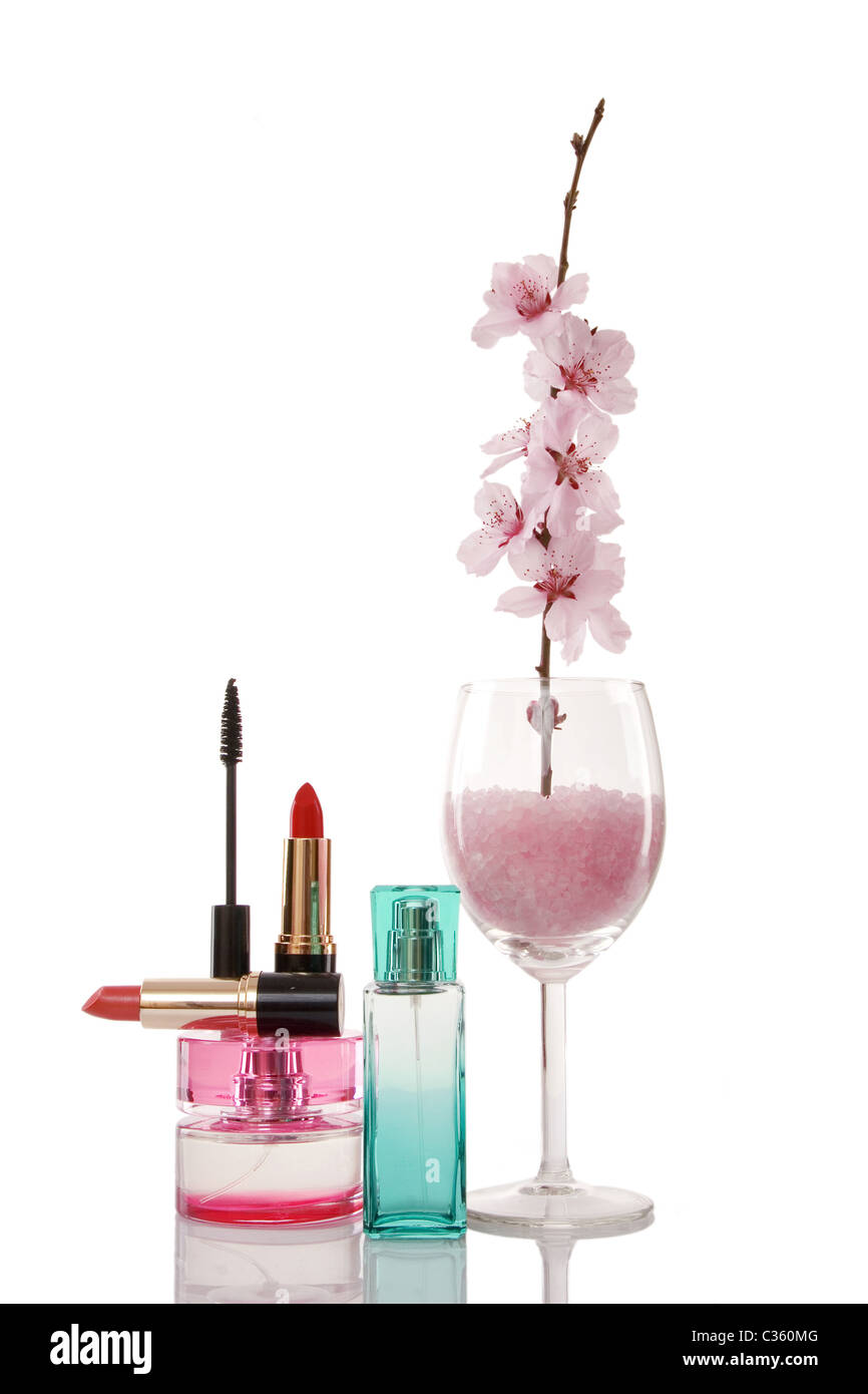 Parfüm-Flaschen, Lippenstifte, Kosmetik und Kirsche Blume auf weißem Hintergrund Stockfoto