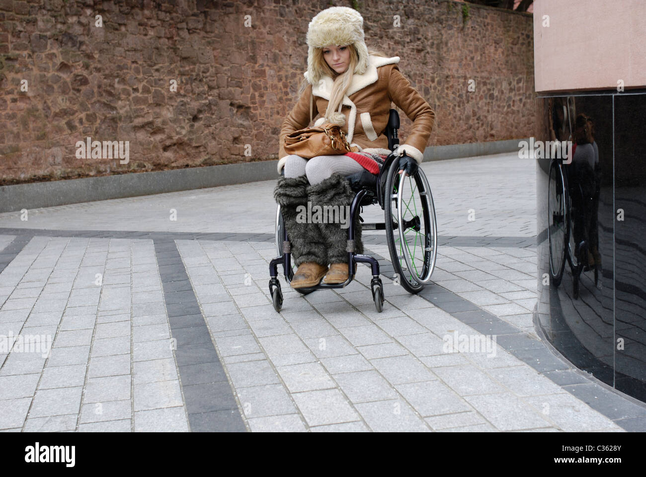 Junge Frau mit der Bedingung Friedreich Ataxie mit einem Rollstuhl. Stockfoto