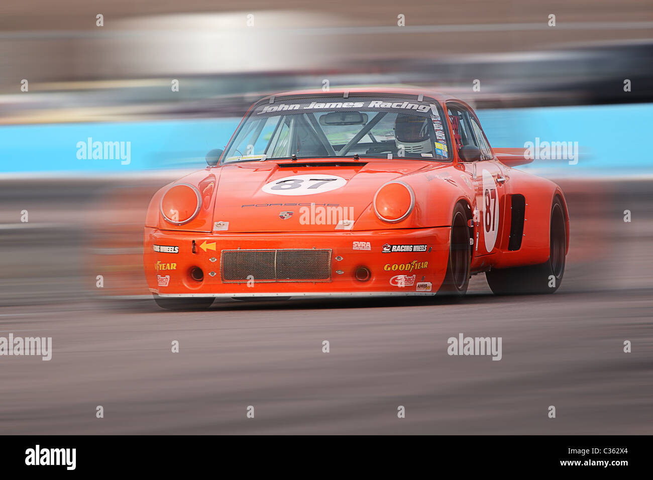 Abstrakte Bewegungsunschärfe von einer orange Vintage Porsche-Rennwagen Stockfoto