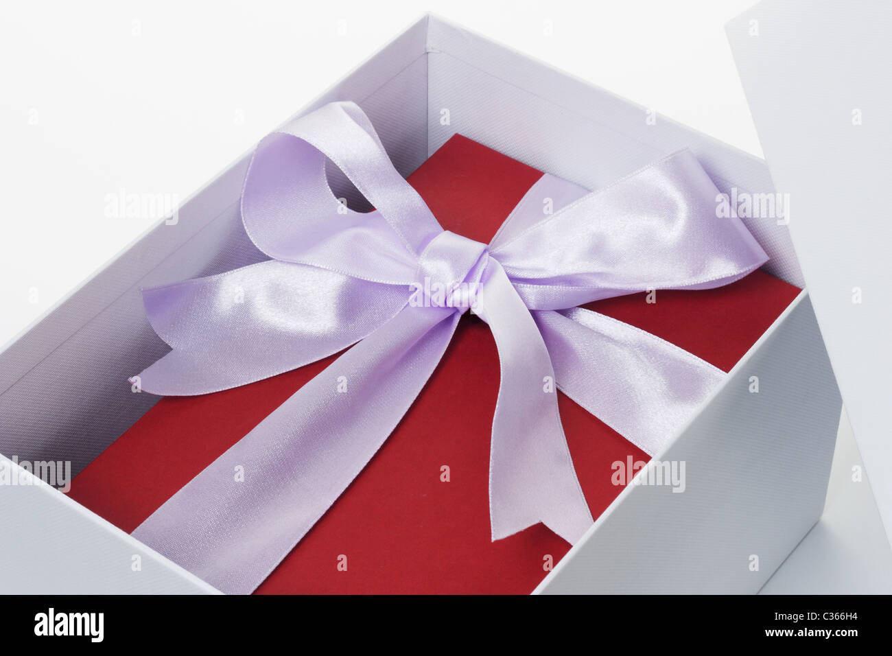 Nahaufnahme von roten Geschenkbox mit Schleife Band in offenen weißen Feld auf isolierte Hintergrund Stockfoto