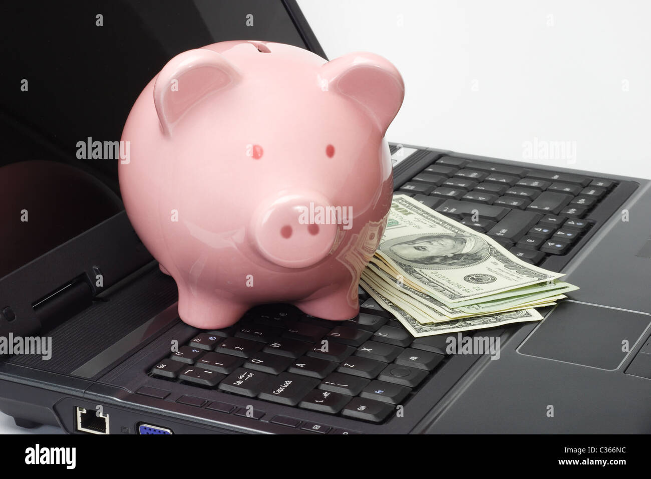 Konzeptbild Sparschwein, US-Dollar und Laptop - Internet-Banking Stockfoto