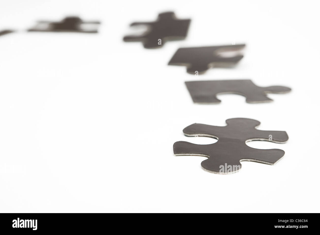 verschiedene schwarze Puzzleteile auf weißem Hintergrund Stockfoto