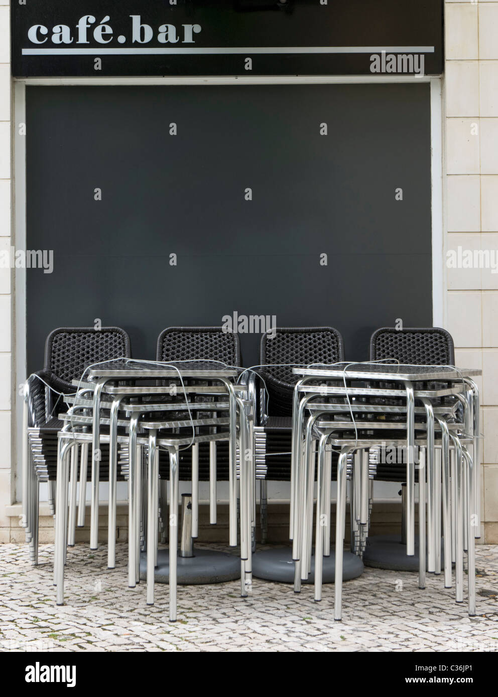 Stühle und Tische gestapelt vor einer geschlossenen Cafébar Stockfoto