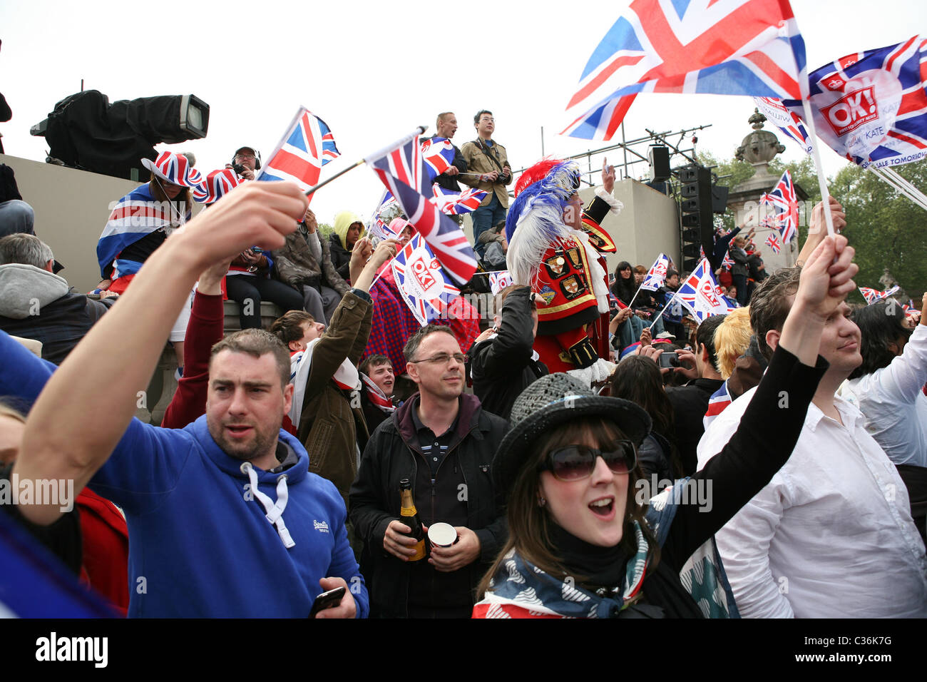 Menschen feiern die Ankunft von Prinz William und Kate Middleton im Buckingham-Palast nach der Trauung von ihrer Hochzeit. Stockfoto