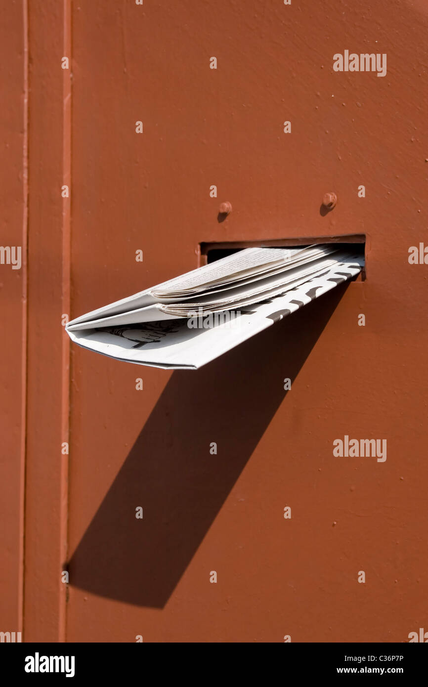 Vorderansicht des gelieferten Zeitung auf rote Tür Stockfoto