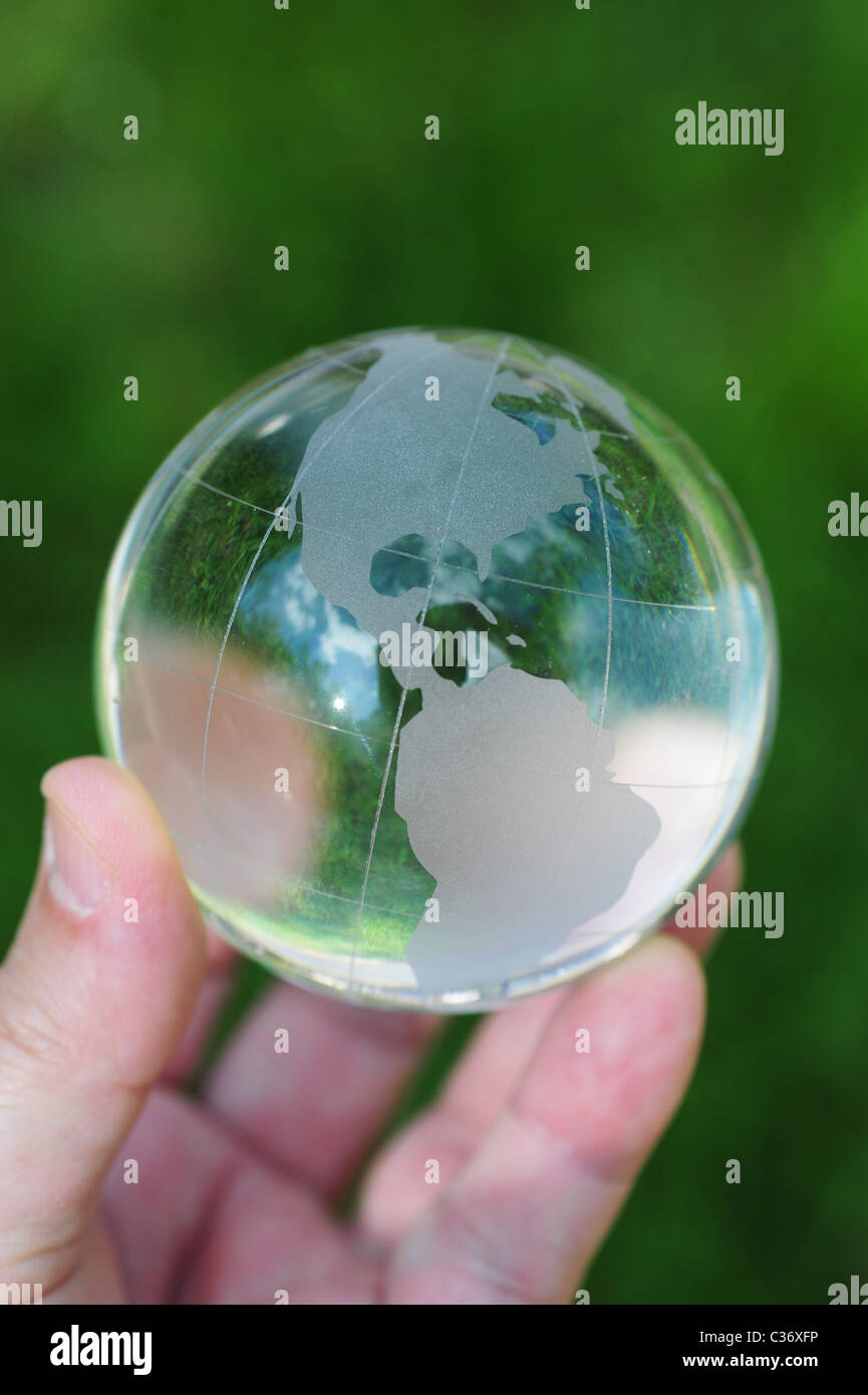 Hand mit Glaskugel im grünen Rasen Erderwärmung Klima-Änderung-Erde-Umwelt-Gesundheit Stockfoto