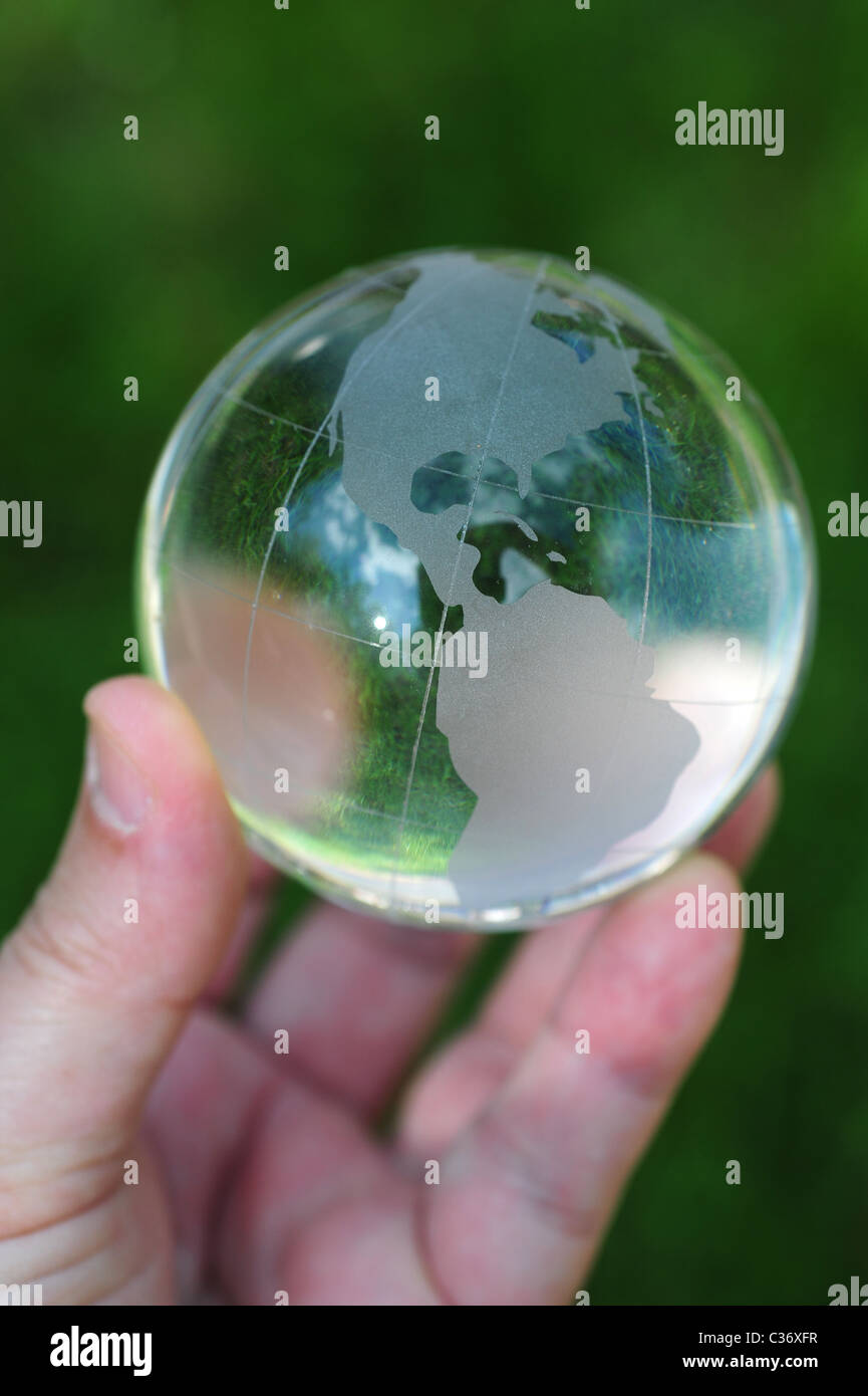 Hand mit Glaskugel im grünen Rasen Erderwärmung Klima-Änderung-Erde-Umwelt-Gesundheit Stockfoto