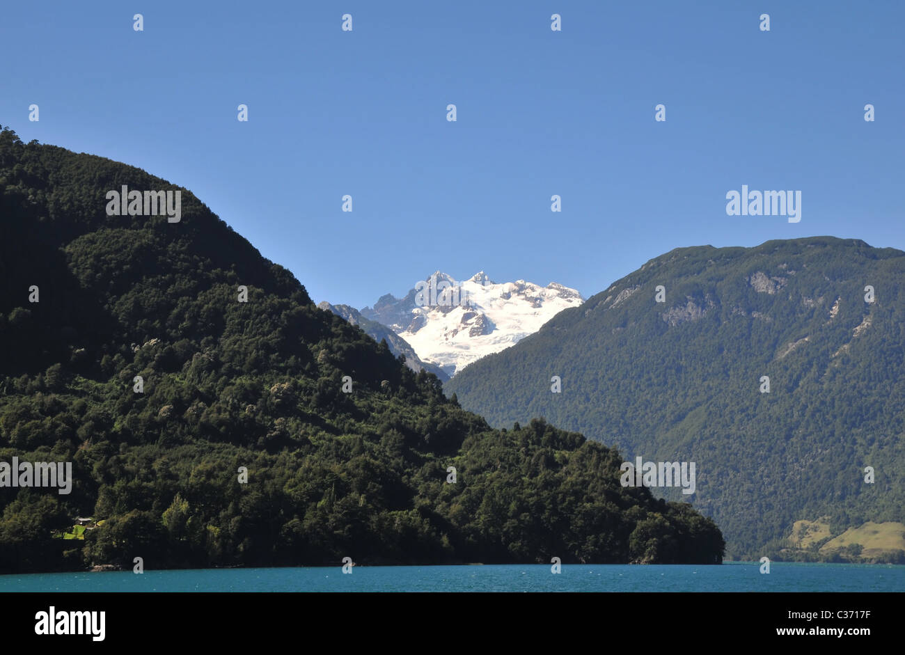 Blauer Himmel, weiße Gipfel Volcan Tronador über Anden Berghänge mit gemäßigten Regenwald, aus LakeTodos Los Santos, Chile Stockfoto